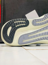 Close-up of the outsole of Silver Blue Adidas Supernova Rise 3 a sneaker, showing a cream-colored midsole with gray and black tread patterns.