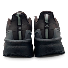 A pair of Triple Dark Brown Adidas Ultraboost 5 TR Shoes in dark brown and black, featuring a textured black midsole, dark gray heel overlays, and light gray pull tabs with the Adidas logo.