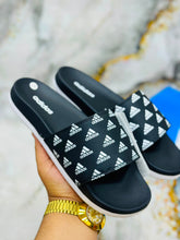 Black strap with printed logo pattern on Adidas Walkfree Unisex Printed Fur Room Slippers 2.0