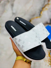 White strap with printed logo pattern on Adidas Walkfree Unisex Printed Fur Room Slippers 2.0
