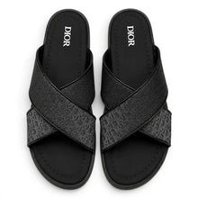 A pair of black Christian Dior slide sandals with textured gray crisscross straps, shown from a top-down view on a white background.