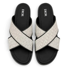 Pair of Dior sandals with criss-cross design on a white background