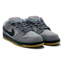 A pair of Nike Dunk Low sneakers in gray suede and mesh with a dark green Swoosh, black laces and midsole, and a yellow gum outsole, shown on a white background.